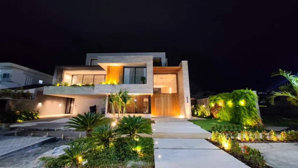 Residência no Condomínio Mansões, Barra da Tijuca: fachada iluminada à noite